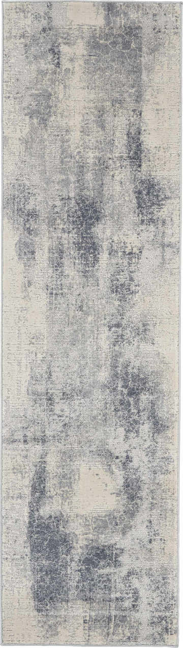 Close-up of the Nourison Rustic Textures Blue Ivory Area Rug, showing its distressed, modern pattern and soft texture.