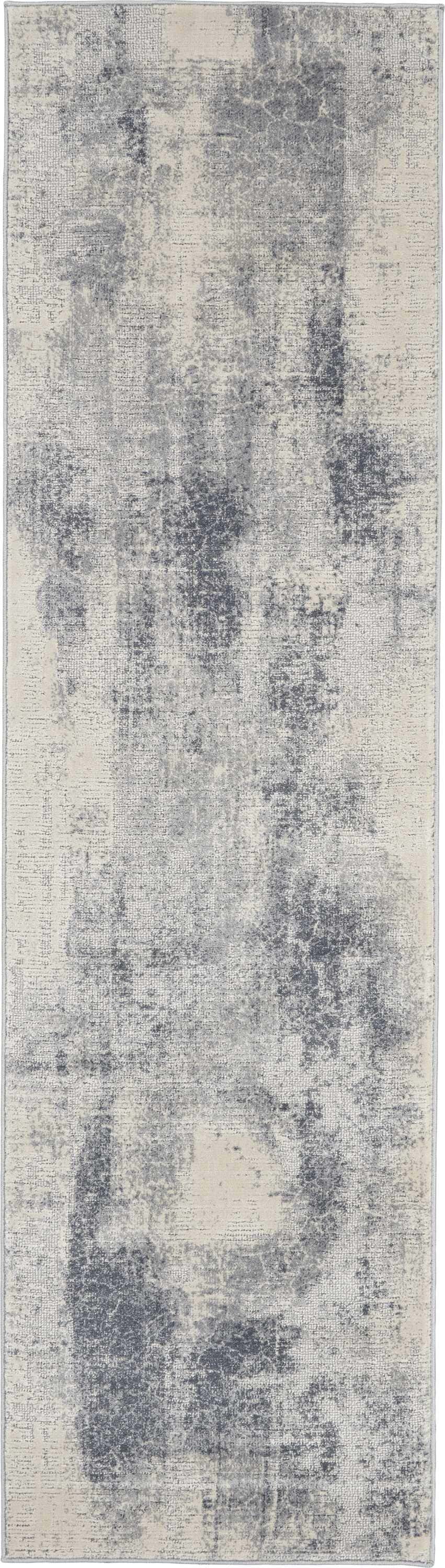 Close-up of the Nourison Rustic Textures Blue Ivory Area Rug, showing its distressed, modern pattern and soft texture.