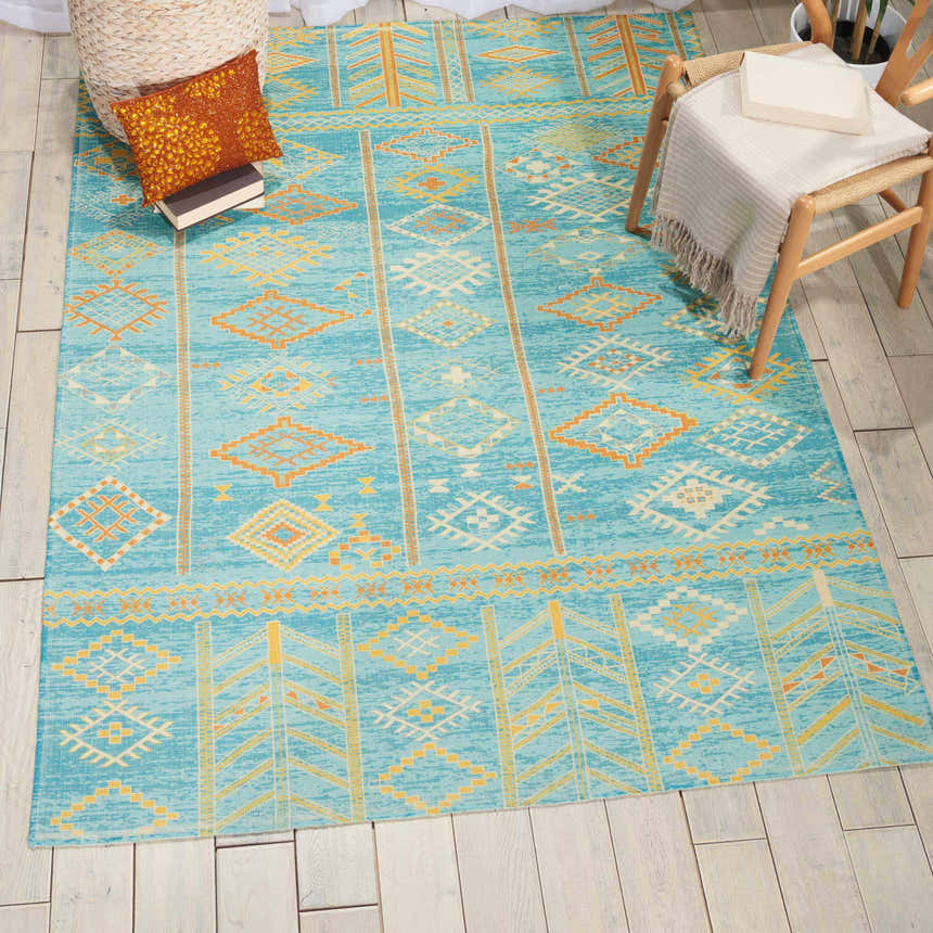 Styled room featuring Nourison Madera Sky Blue Tribal rug. Sky blue and gold geometric pattern on a wood floor.
