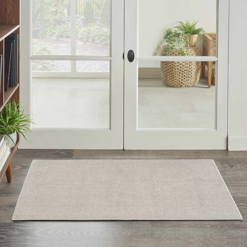 Entryway scene with a Nourison Natural Texture Ivory Mocha area rug on dark wood floors.