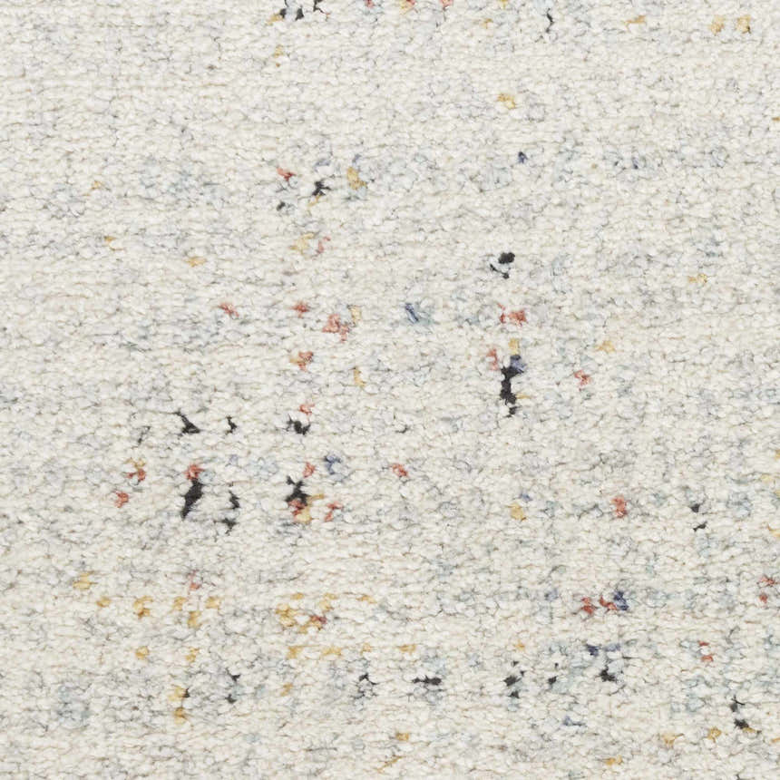 Close-up of the Nourison Motion Multicolor rug. Low pile texture with flecks of black, red, yellow, and blue on a cream background.