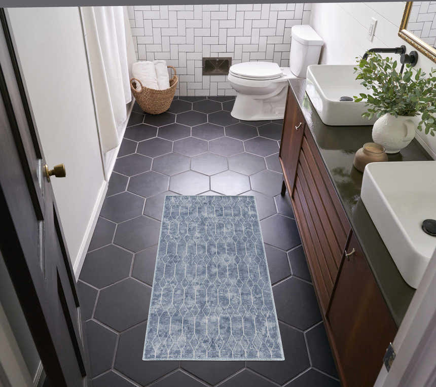Modern bathroom with Nourison New Concept Blue rug on black hexagon tile, white subway tile, and wood vanity.