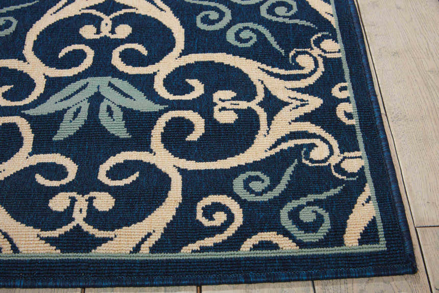 Close up of the Nourison Caribbean Navy Contemporary Area Rug with a cream and light blue floral scroll pattern.