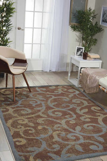 Living room scene with Nourison Expressions Multicolor rug, chair, white side table, and natural light.