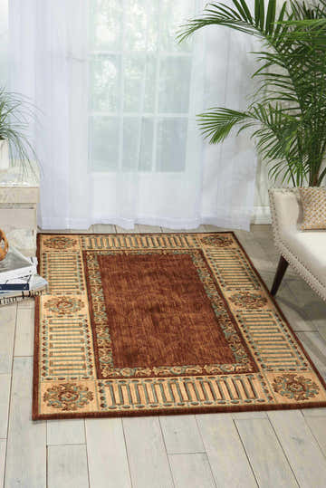 Living room scene with a Nourison Vallencierre Brown vintage rug, cream sofa, and light wood floors.