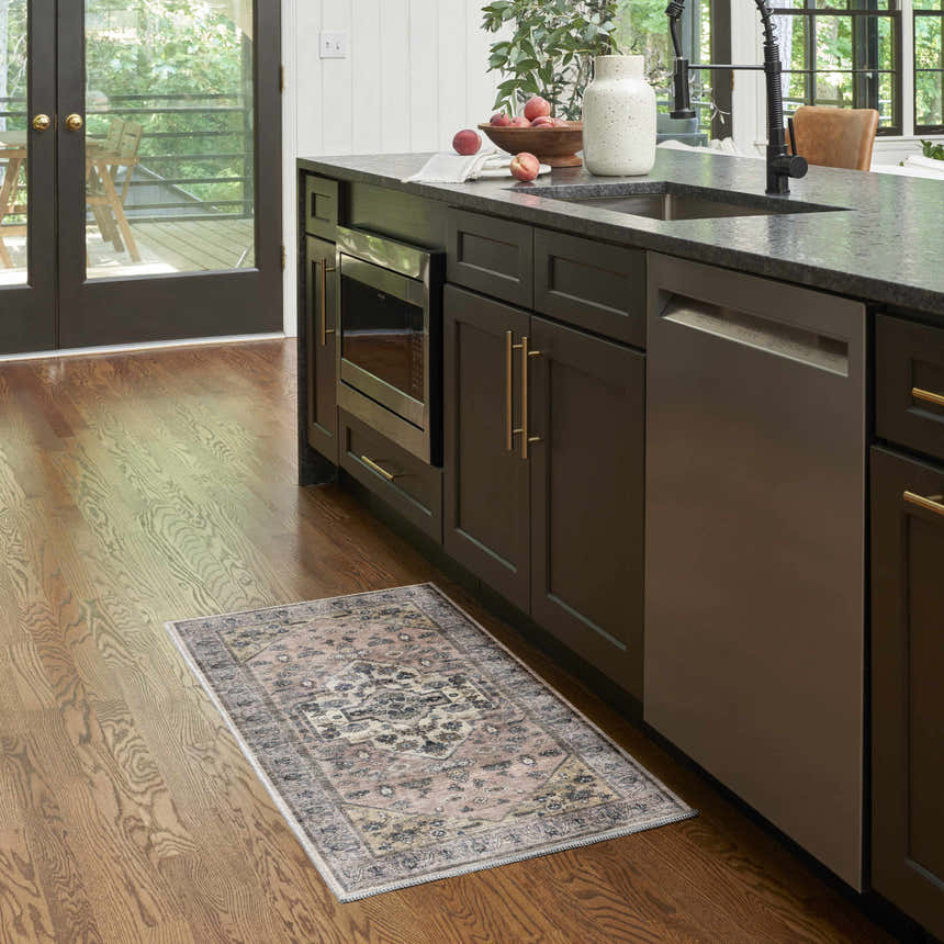Kitchen scene with Nourison Grand s Blush Vintage Area Rug on hardwood floor near dark cabinets.