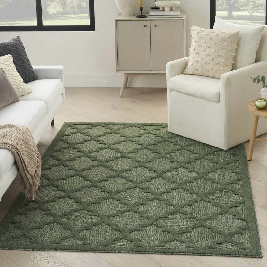 Living room with white sofa and Nourison Easy Care Green Modern Area Rug with geometric pattern.