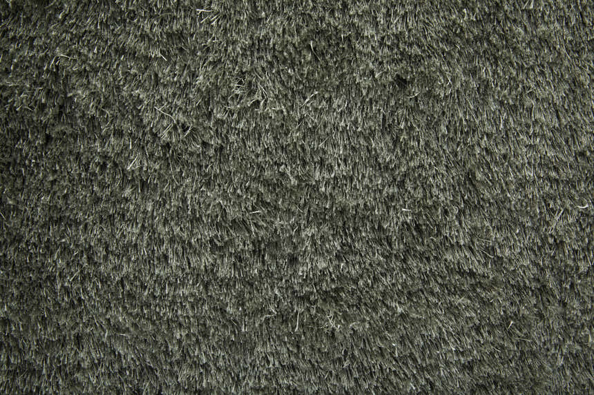 Close-up of the Feizy Indochine Modern Solid Green Area Rug, showing its plush, hand-tufted texture and subtle green color. Texture