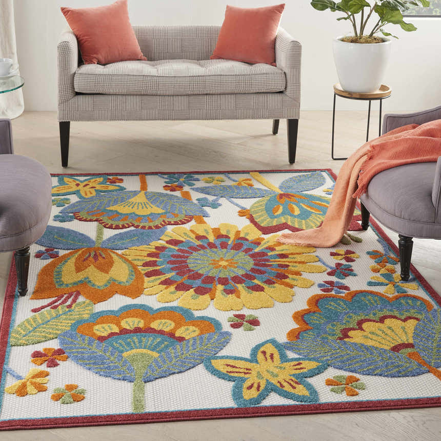 Living room scene with a Nourison Aloha Multicolor rug featuring floral patterns in blue, yellow, and orange.