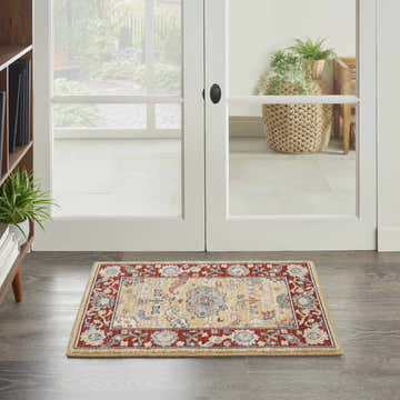 Entryway with Nourison Parisa Gold Brick rug, a traditional wool runner with red and gold floral pattern on gray wood floor.
