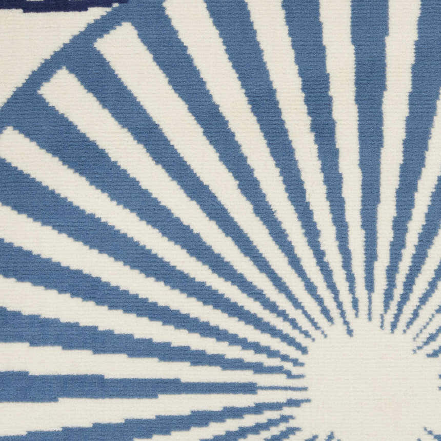 Close-up of the Nourison Grafix White Contemporary Indoor Area Rug with a blue and off white sunburst pattern.