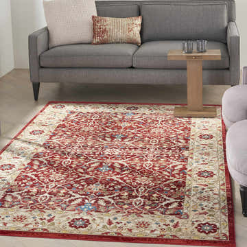 Living room scene with a gray sofa and the Nourison Karisma Brick Ivory rug. The rug has a red and ivory floral pattern.