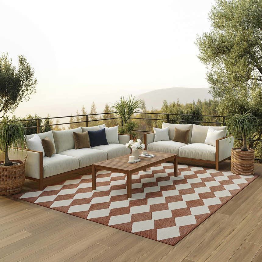 Outdoor patio scene with a Nourison Positano Terracotta rug, white sofas, wood coffee table, and mountain view.