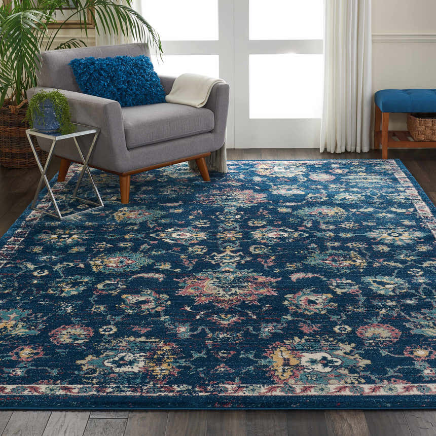 Living room scene with a Nourison Fusion Navy Pink Persian rug, gray chair, and blue accents.