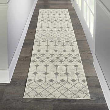 Hallway with Nourison Grafix Ivory/Grey Bohemian Indoor Area Rug runner on dark wood floor.