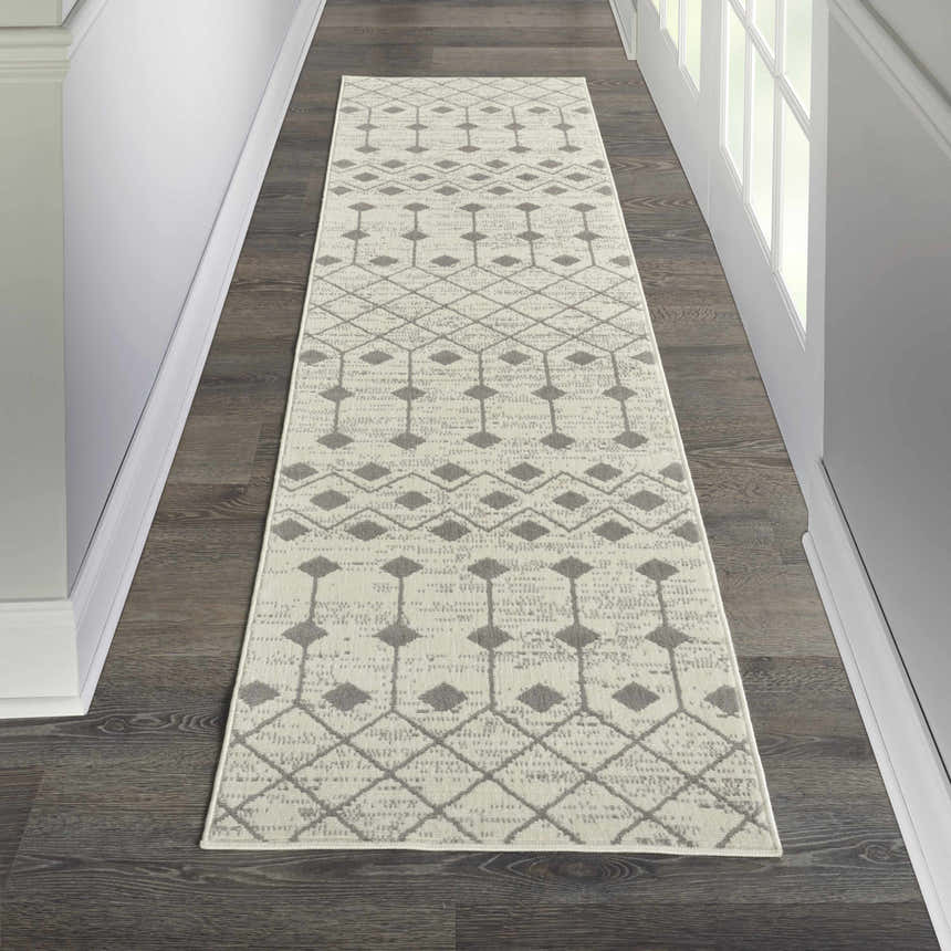 Hallway with Nourison Grafix Ivory/Grey Bohemian Indoor Area Rug runner on dark wood floor.