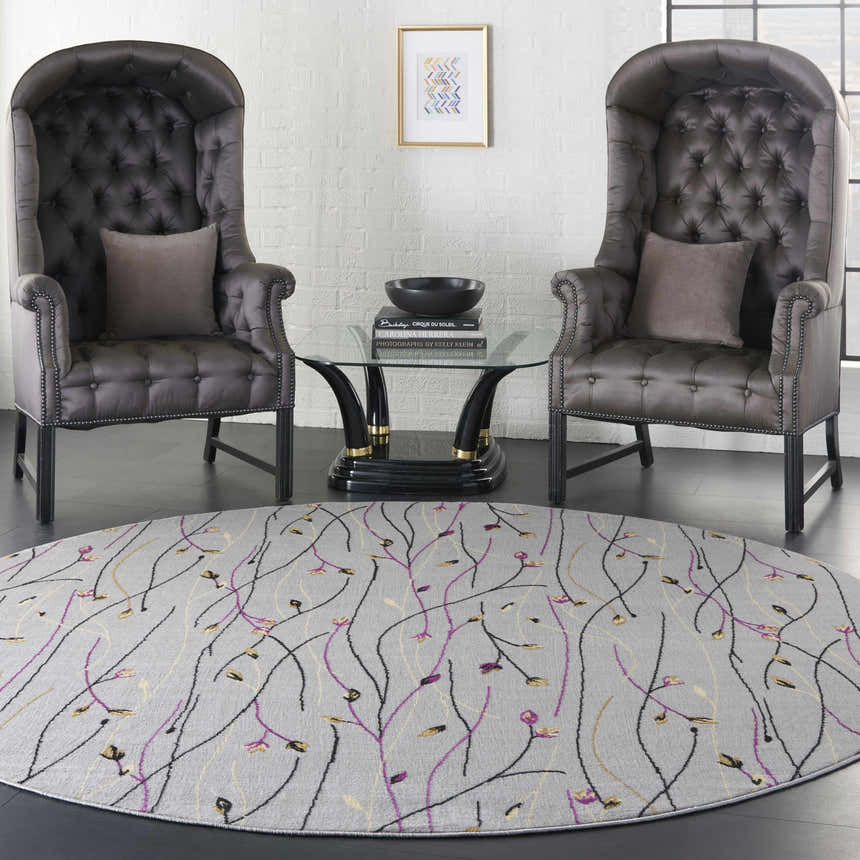 Living room scene with grey wingback chairs and round Nourison Grafix Grey Contemporary Indoor Area Rug.