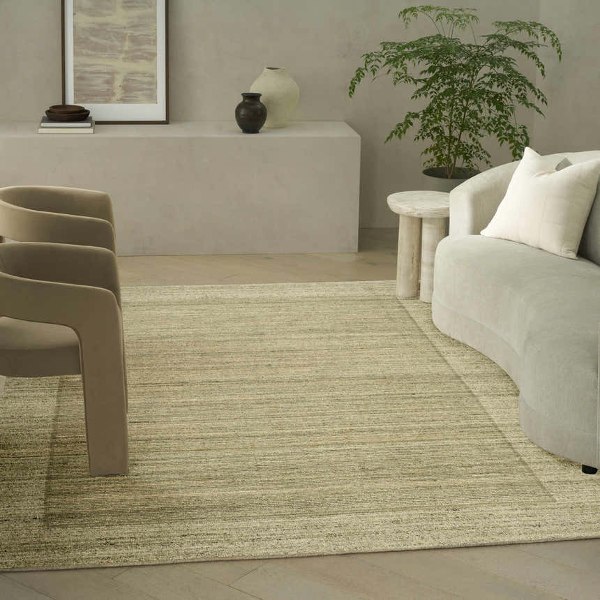 Neutral living room featuring a Calvin Klein CK082 Ridge Sage Ivory rug, curved sofa, and modern decor.