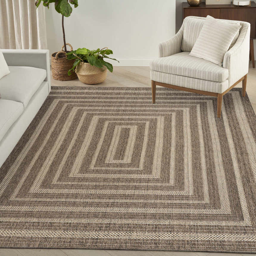 Living room scene with a Nourison Tulum Brown Outdoor Area Rug featuring a geometric square pattern.