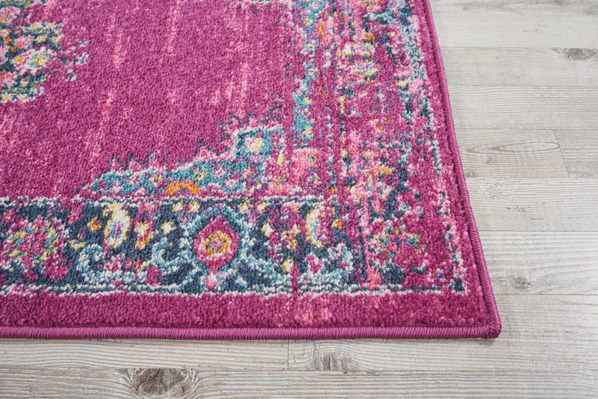 Close-up of Nourison Passion Fuchsia rug showing bohemian pattern, vibrant fuchsia, blue, and pink colors, and soft texture.