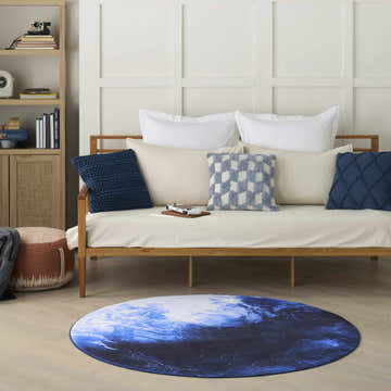 Kids room scene with a blue Nourison Imagination round rug, wooden daybed, and light wood bookshelf.