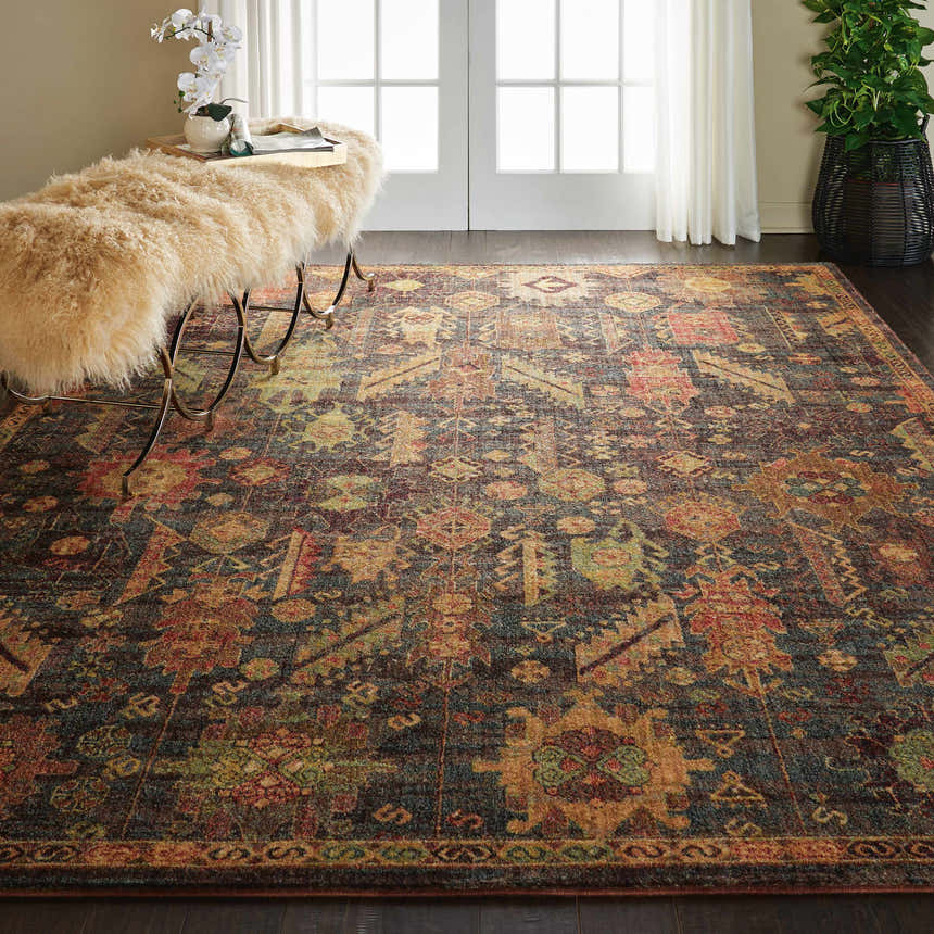 Living room scene with a Nourison Jewel Denim Persian rug, wood floors, and a sheepskin-covered bench.