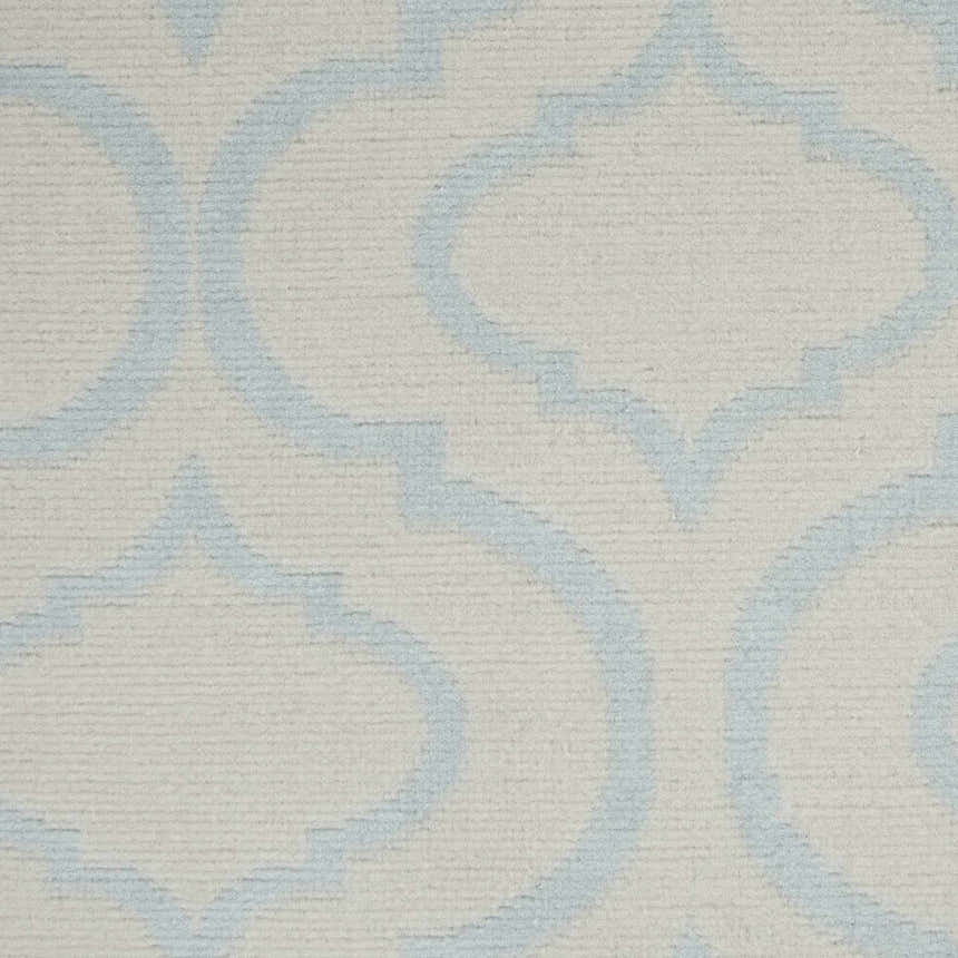 Close-up of the Nourison Jubilant Ivory Blue rug, featuring a light blue quatrefoil pattern on an ivory background.