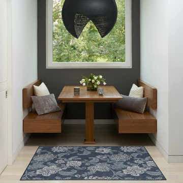 Breakfast nook with wood benches and Nourison Garden Oasis Navy Tropical Area Rug.
