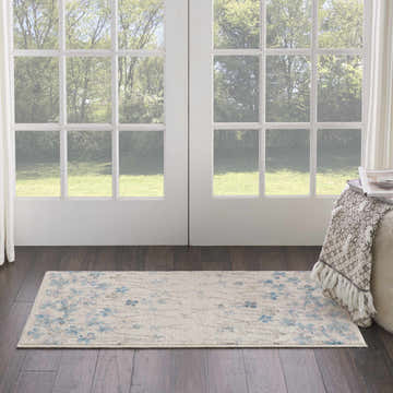Nourison Tranquil Ivory rug in a sunlit room with dark wood floors and white french doors. Contemporary floral runner.