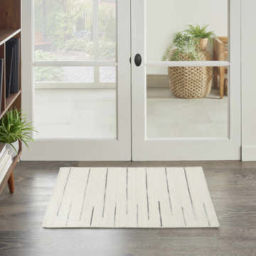 Entryway with Nourison Interweave Ivory rug, wood floors, and white double doors to a garden view.