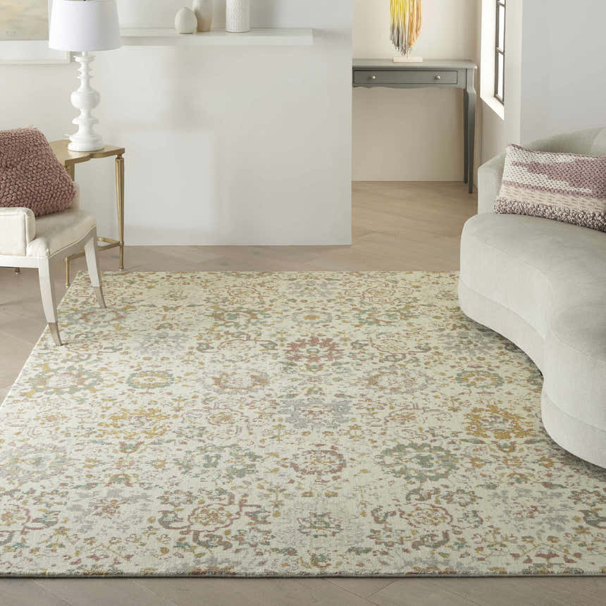 Living room scene with a Nourison Twilight Ivory Multicolor rug, curved sofa, and wood floors.