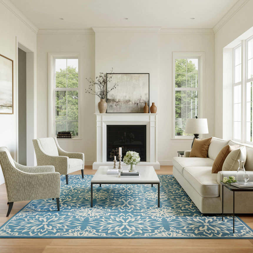Living room scene with a Nourison Jubilant Ivory Blue Farmhouse Indoor Area Rug, sofa, chairs, and fireplace.