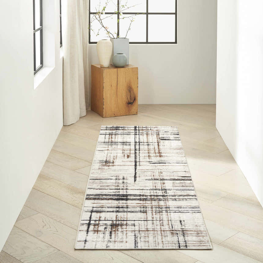 Hallway scene with Calvin Klein CK029 Captivating Ivory Multicolor rug, wood floors, natural light, and modern decor.