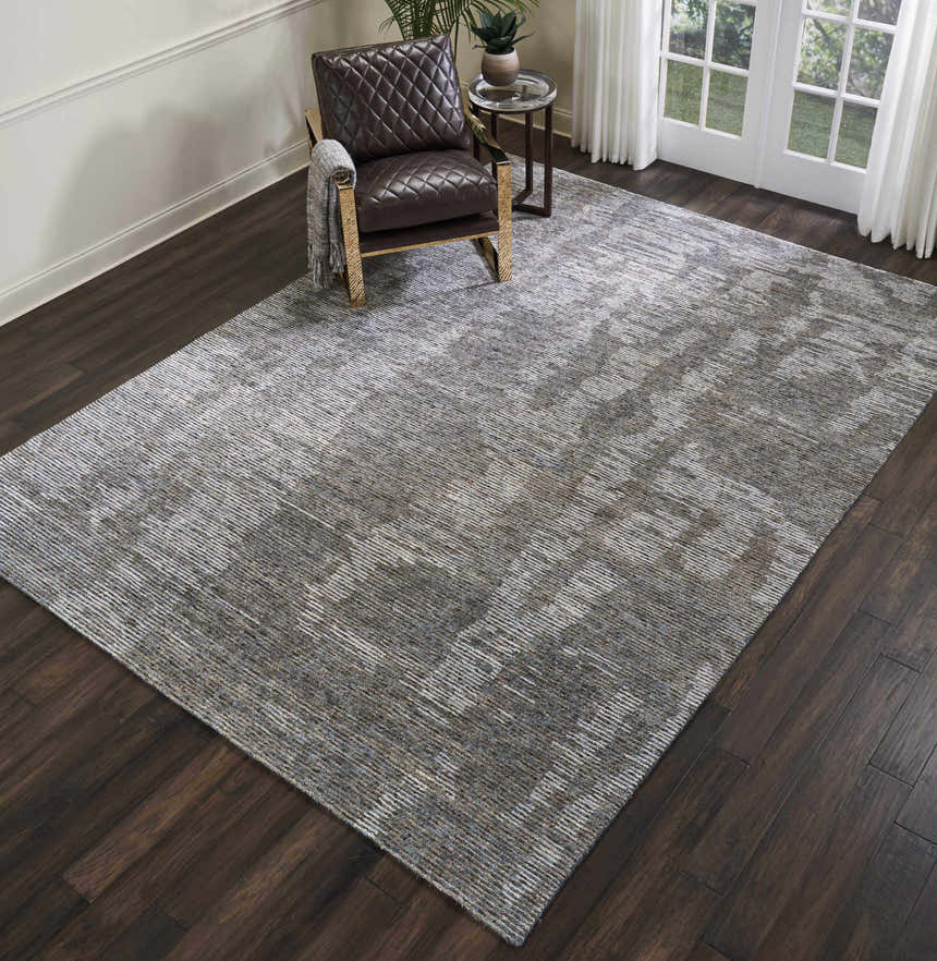 Living room scene with a brown leather chair on a Nourison Ellora Slate modern area rug.