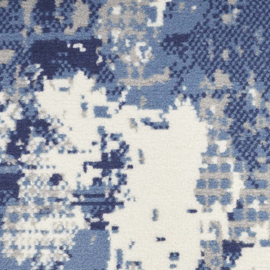 Close-up of the Nourison Grafix Navy Blue rug, featuring an abstract pattern in navy, light blue, gray, and white.