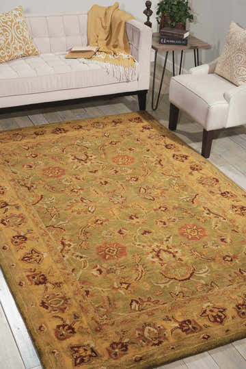 Living room scene with a Nourison Jaipur Green Persian rug, cream sofa, and light wood floors.