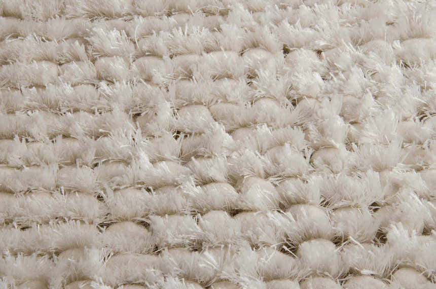 Close-up of the plush, snow white shag texture of the Nourison Fantasia area rug.