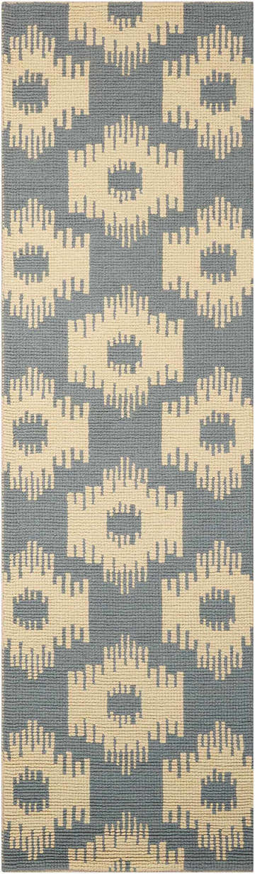 Close-up of Barclay Butera Prism Slate rug. Taupe wool rug with a geometric pattern on a slate blue background.