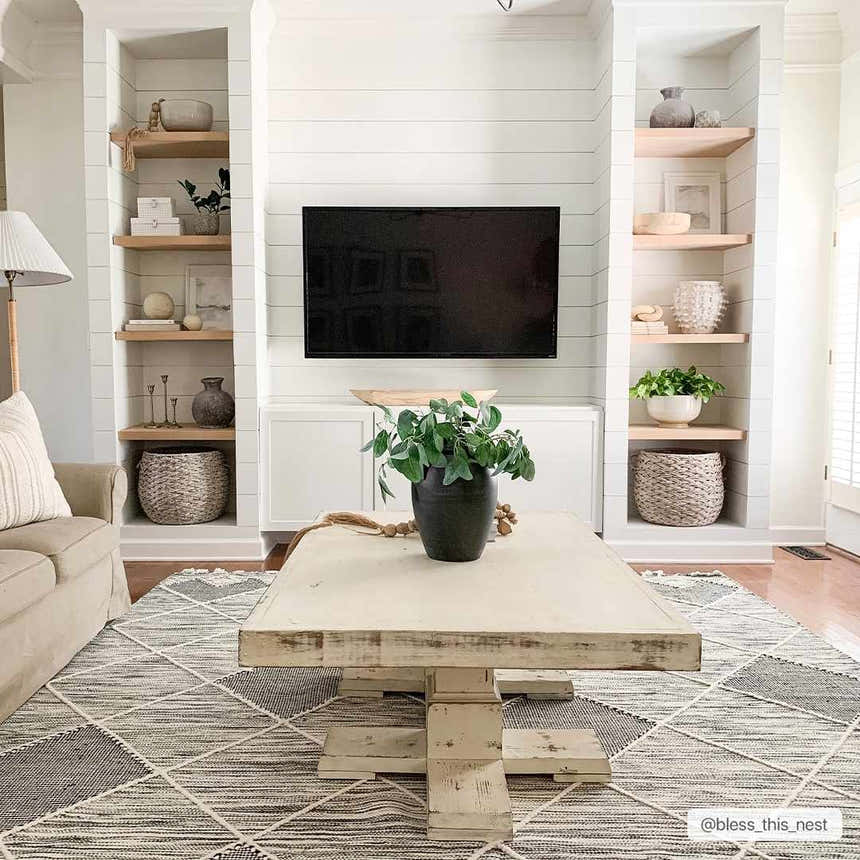 Living room scene with a Mabua Tasseled Jute&Wool Rug in black and cream, styled under a rustic coffee table. Farmhouse decor. Roomscene-Rectangle