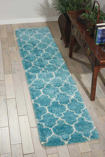 Hallway scene with Nourison Amore Aqua rug runner. Aqua shag rug with white Moroccan lattice pattern on light wood floor.