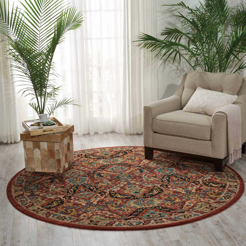 Living room scene with a round Nourison 2020 Terracotta rug, beige armchair, plants, and light wood floors.