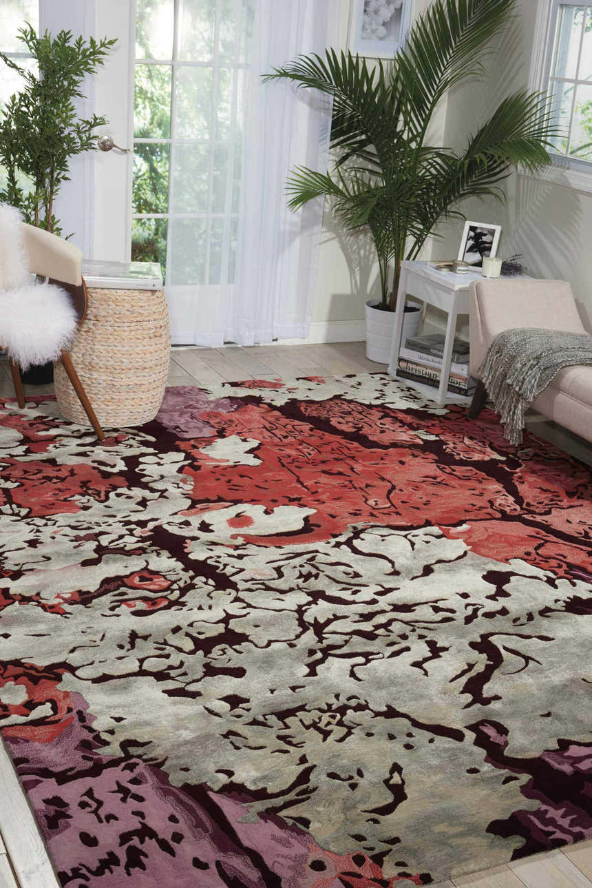 Living room scene with a painterly Nourison Prismatic Multicolor rug, chaise lounge, woven stool, and bright natural light.