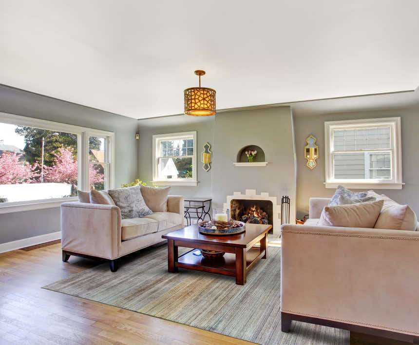 Living room scene with a Feizy Milan blue/purple/tan rug, sofas, fireplace, and wood floors. Roomscene-Rectangle