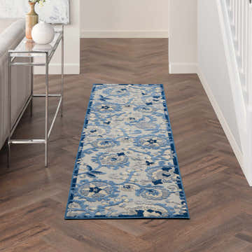 Hallway scene with Nourison Aloha Blue Grey Farmhouse Area Rug runner on wood floors. Console table with vases.