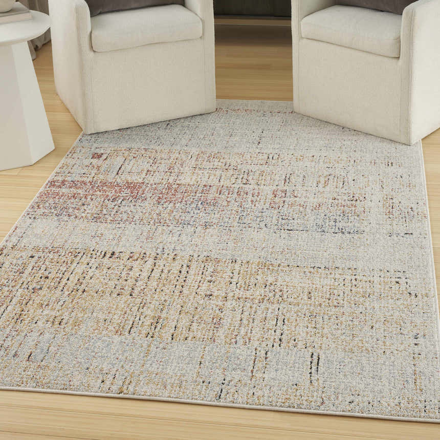 Living room scene with Multicolor Nourison Motion Rug, light wood floors, and two cream-colored armchairs.