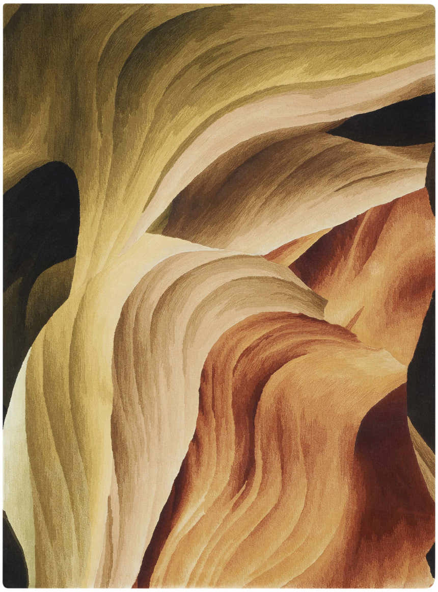 Close-up of Nourison Prismatic Multicolor rug. Abstract design with flowing lines in shades of gold, tan, brown, and black.