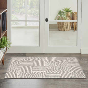 Entryway scene with Nourison Natural Texture Grey Ivory rug, geometric pattern, on dark wood floor near white doors.