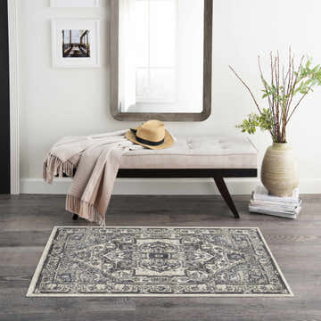 Entryway with bench and Nourison Quarry Ivory Navy Vintage Area Rug on dark wood floor.