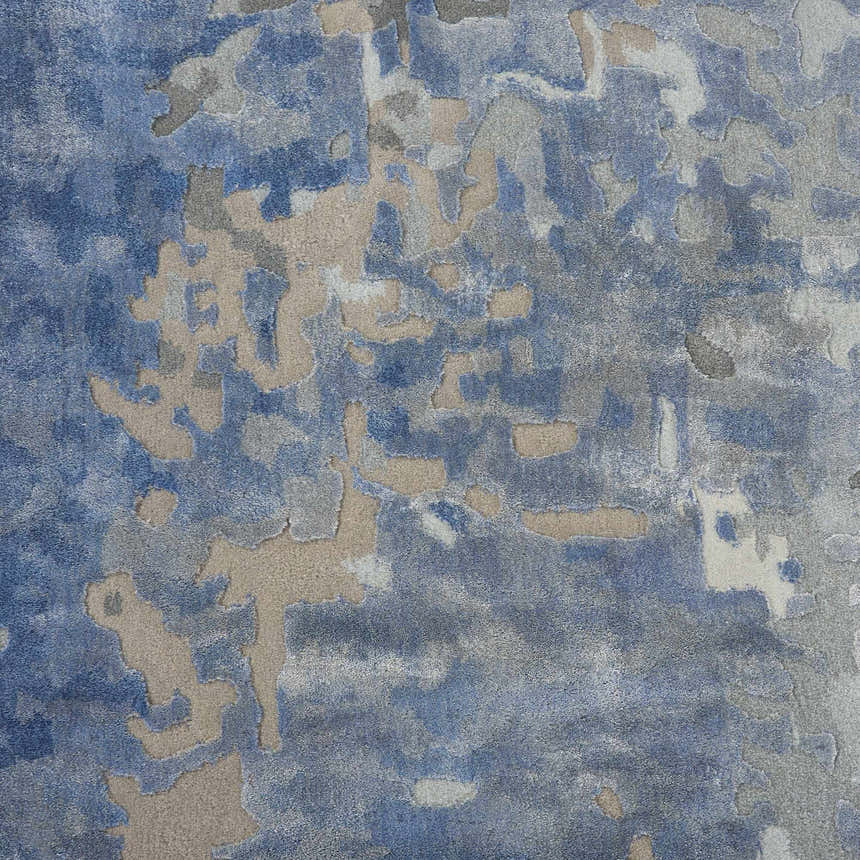 Close-up of the Nourison Prismatic Denim Rug. Abstract design in denim blue, gray, and beige tones. Handmade wool rug texture.