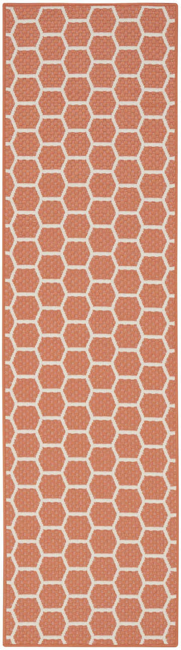 Close-up of Nourison Twist Reversible Coral Area Rug. Honeycomb pattern in coral and cream. Modern, machine-made polypropylene rug.